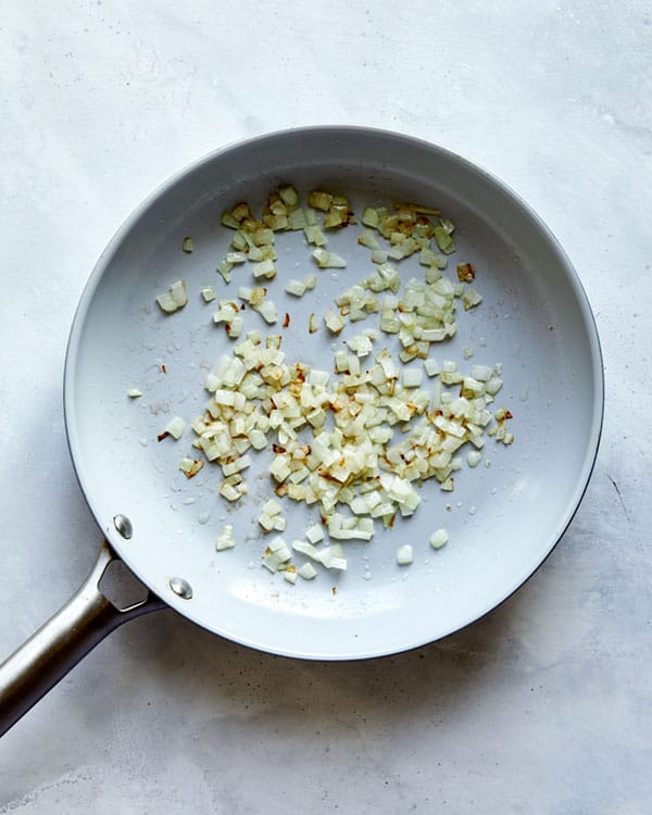 Onions and garlic cooking in a skillet.