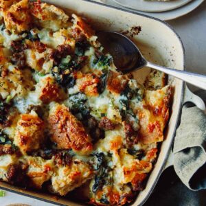Sausage strata recipe in a baking dish with a scoop out.