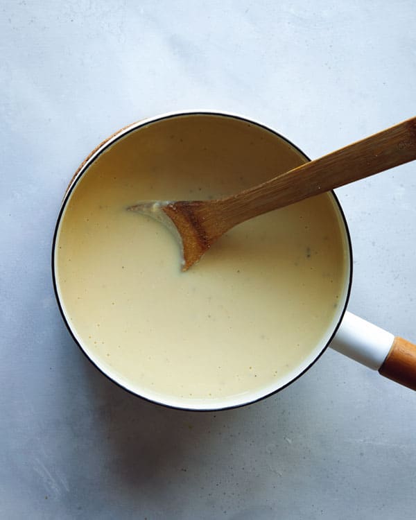 Cooking a cheese sauce in a skillet for stovetop mac and cheese. 