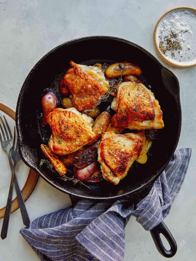 Crispy chicken thighs in a skillet.