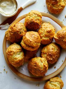 Drop biscuit recipe with sour cream and chives baked on a plate.