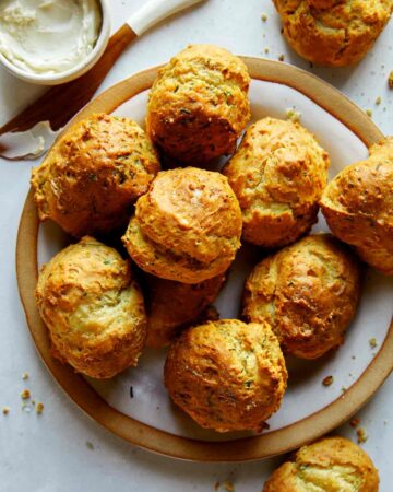 Drop biscuit recipe with sour cream and chives baked on a plate.