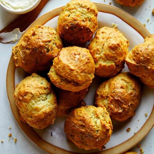 Drop biscuit recipe with sour cream and chives baked on a plate.