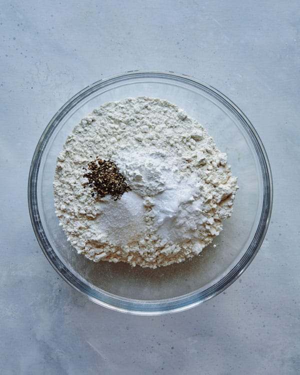 Dry ingredients for drop biscuits in a glass bowl.
