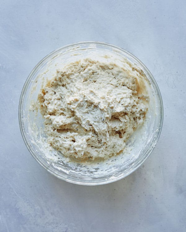Drop biscuit dough combined in a glass bowl looking sticky.