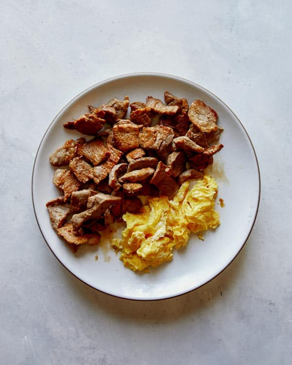 Cooked pork and eggs for pad see ew.