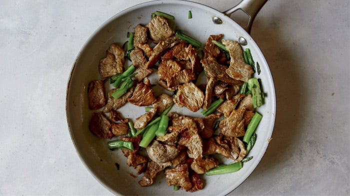 Pork and broccoli in a skillet.