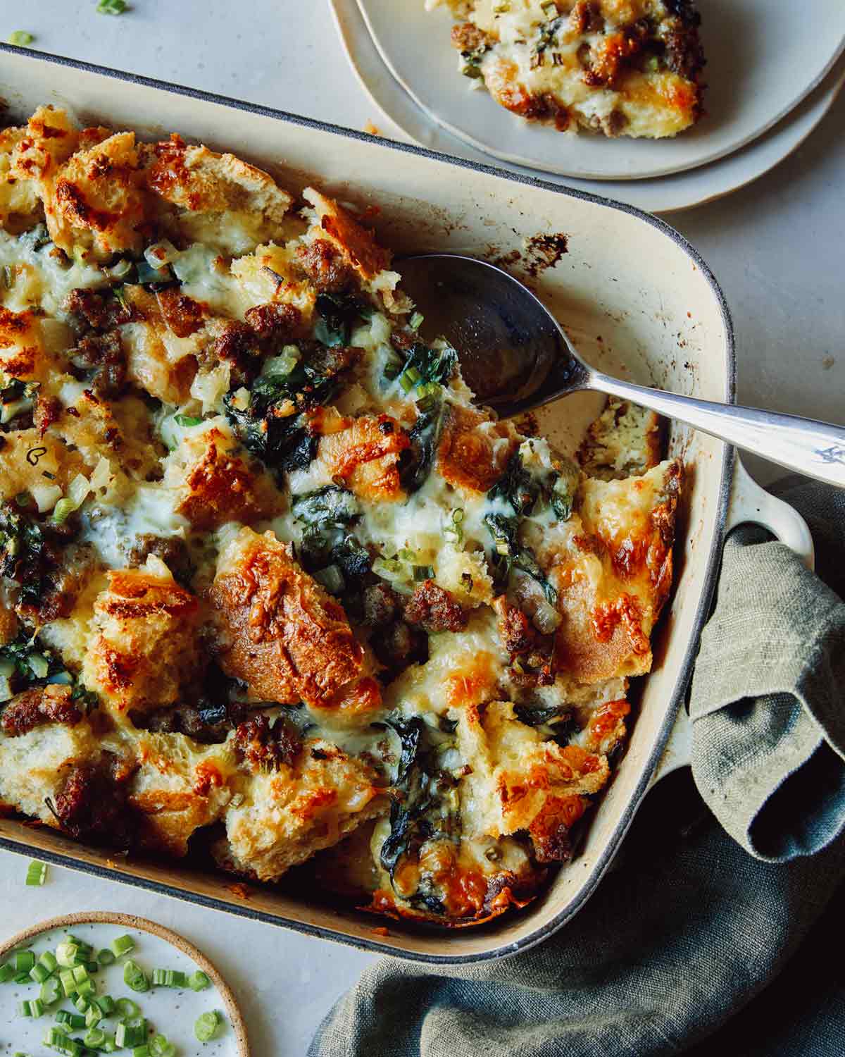 Sausage strata recipe in a dish with a scoop out. 