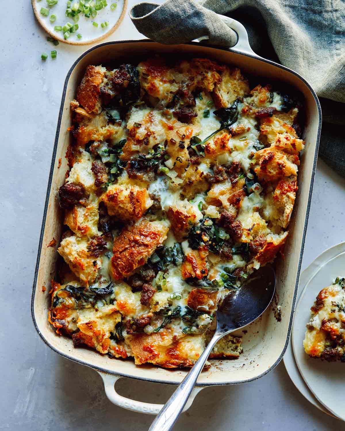 Sausage strata recipe being served onto plates. 