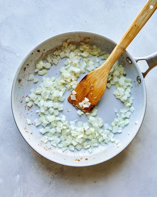 Onions and garlic cooking in a skillet.