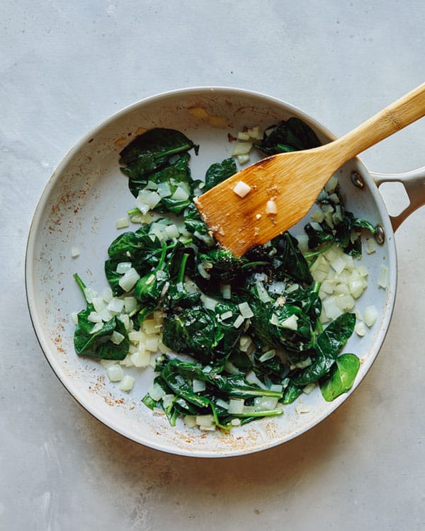 Spinach, onions and garlic in a skillet.