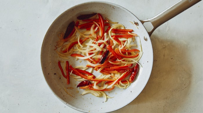 Cooking peppers and chiles in a skillet.