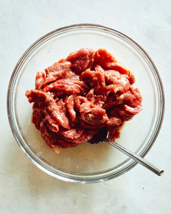 Szechuan beef marinating in a bowl.