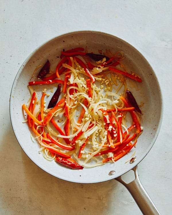 Peppers with ginger and garlic cooking in a skillet. 