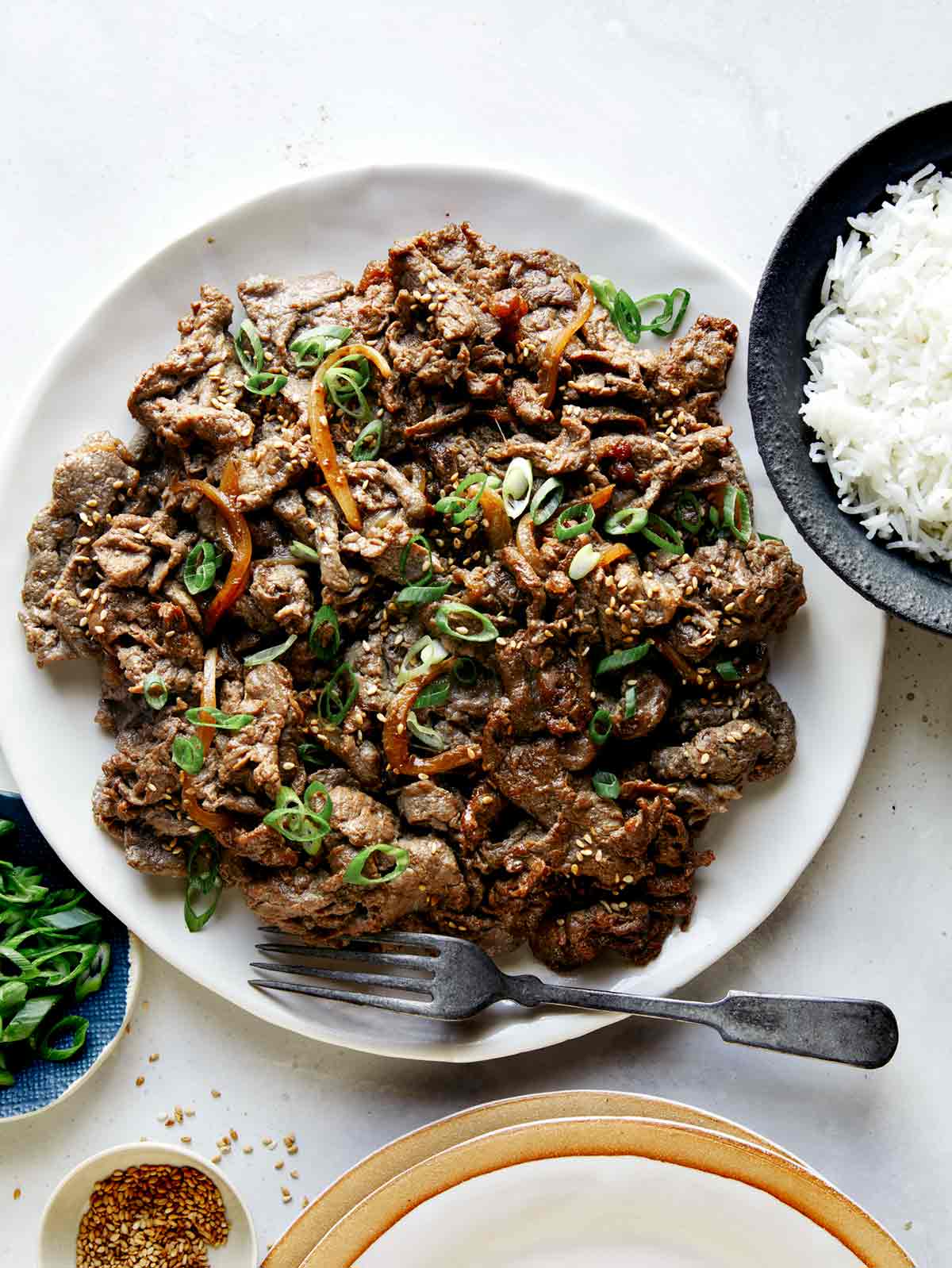 Korean beef bulgogi with rice on the side  and sesame seeds. 