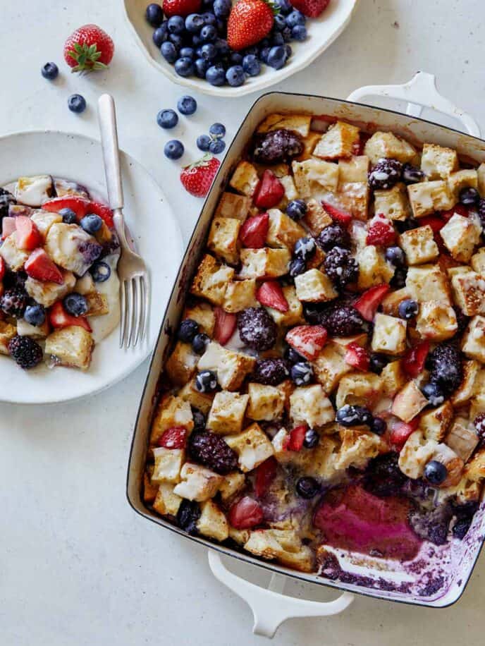 Berry bread pudding recipe being served onto plates. 