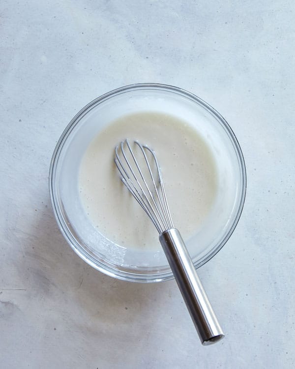 Bread pudding glaze whisked together in a bowl.