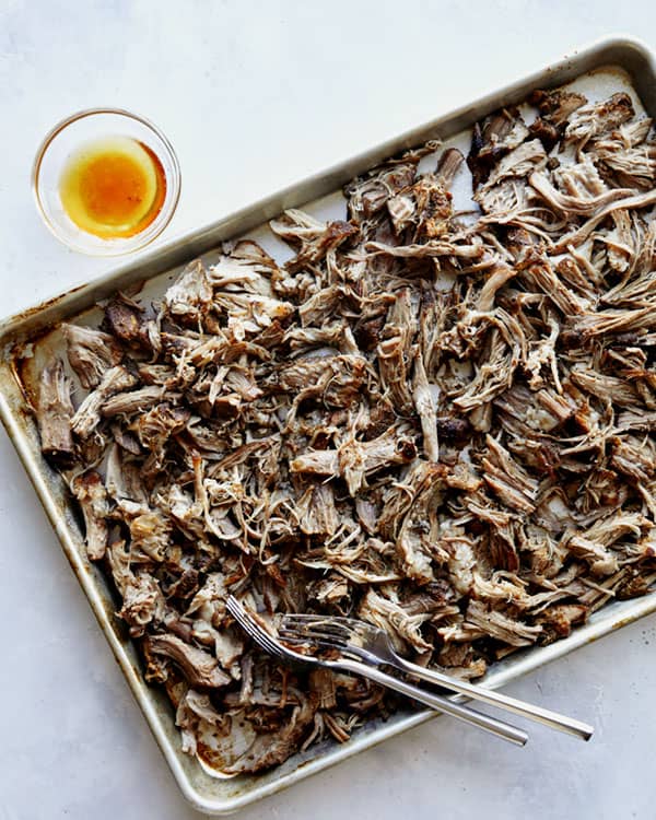 Carnitas recipe shredded on a baking sheet.
