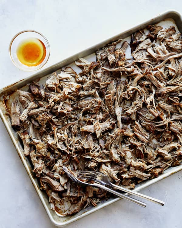 Carnitas recipe shredded on a baking sheet. 