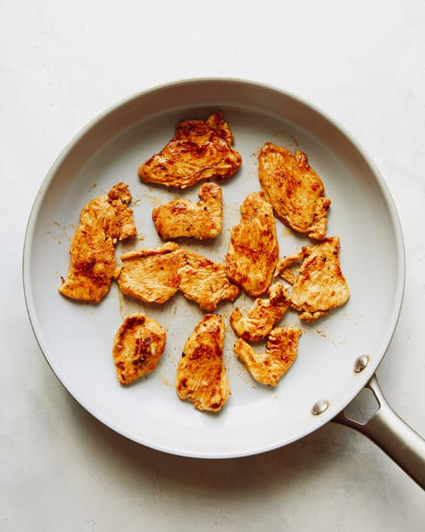 Chicken cooking in a skillet to make chicken fajitas.