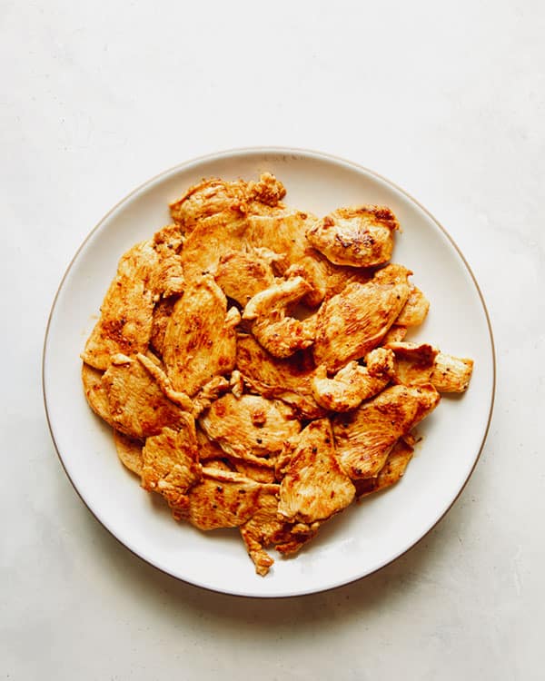 Chicken fajitas pieces resting on a plate.