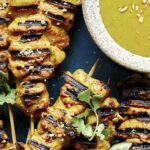 Chicken satay recipe being served onto plates.