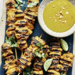 Chicken satay recipe being served onto plates.