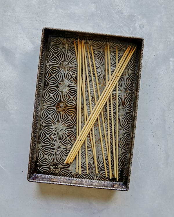 Chicken satay wood skewers soaking.