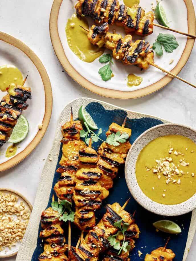 Chicken satay recipe being served onto plates.