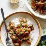 Honey garlic chicken dinner recipe with sesame seeds and green onions.