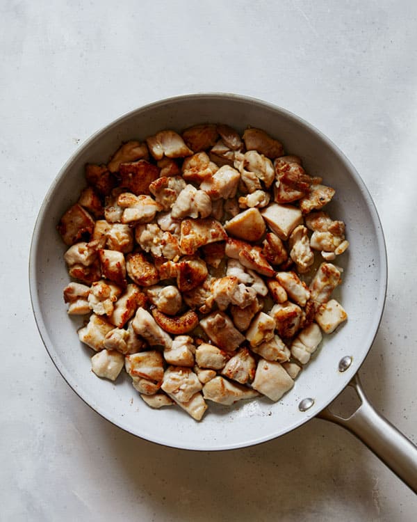 Chicken cooking in a skillet to make honey garlic chicken.