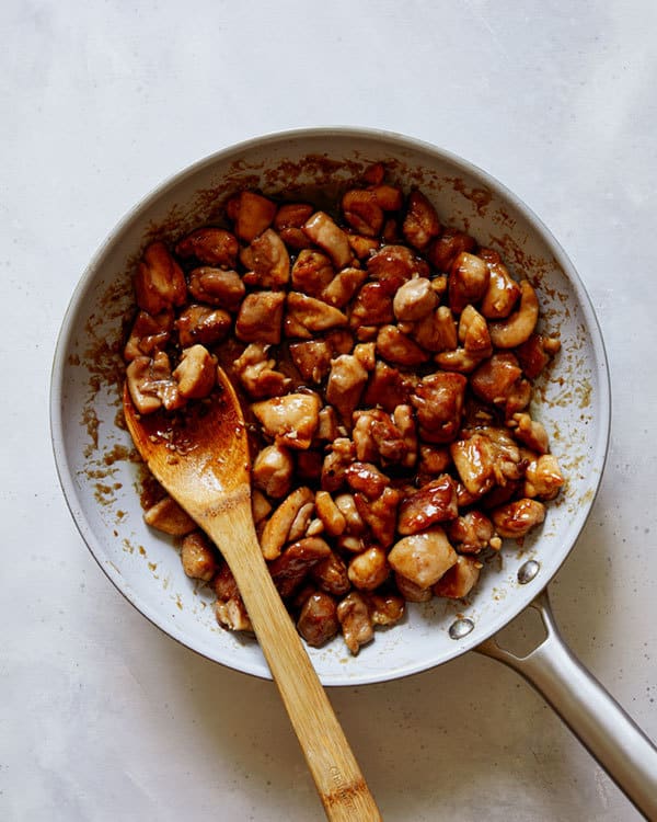 Honey garlic chicken in a skillet cooking.