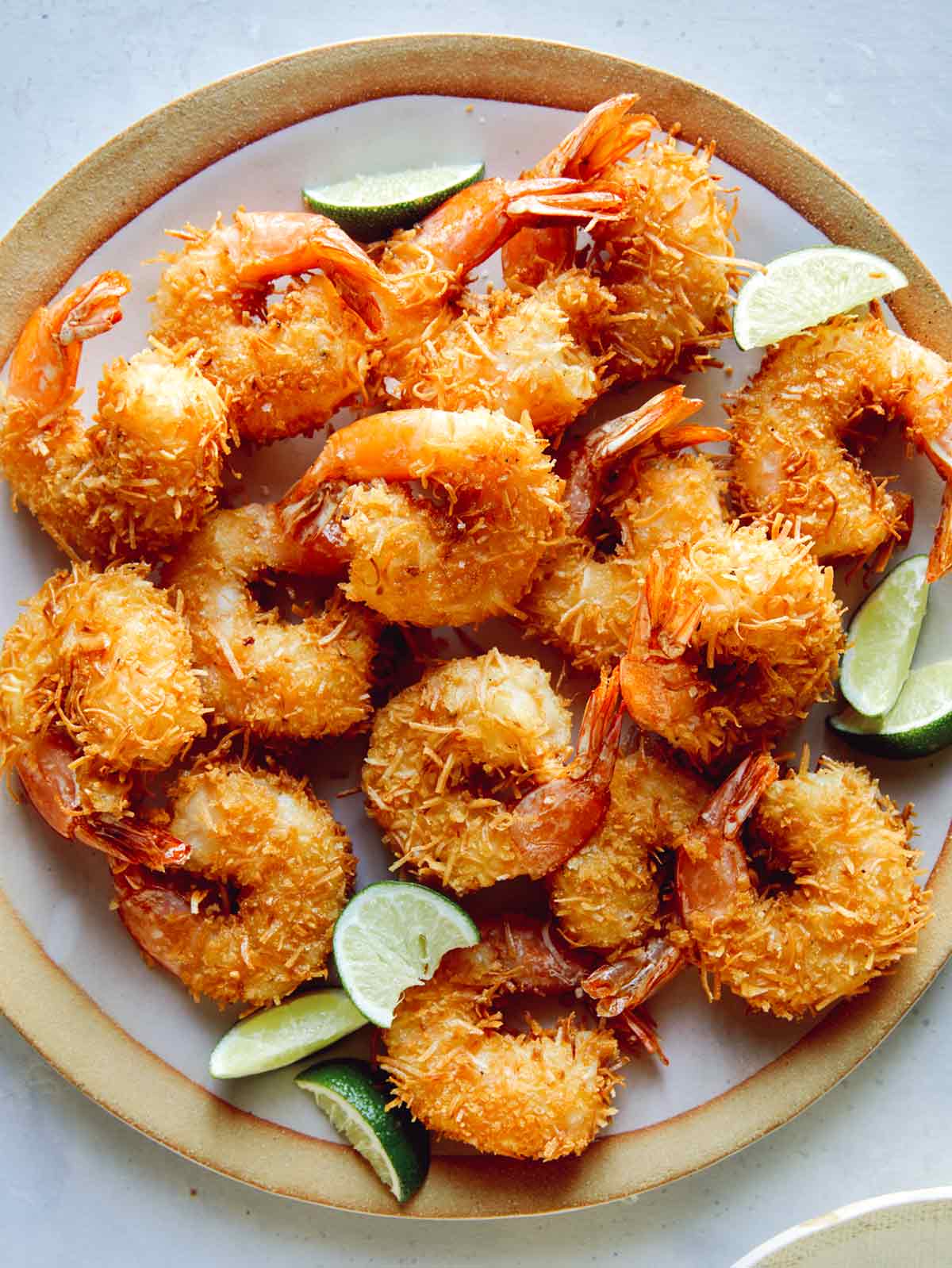 Coconut shrimp with lime wedges on a platter. 