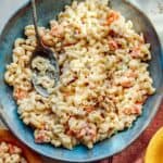 Hawaiian style macaroni salad in a bowl with serving bowls nearby.