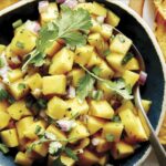 Mango salsa recipe in a bowl with chips.