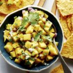 Mango salsa recipe in a bowl with chips.