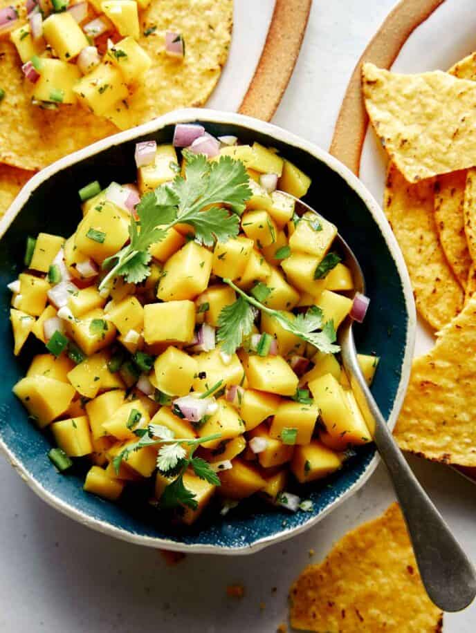 Mango salsa in a bowl with chips. 