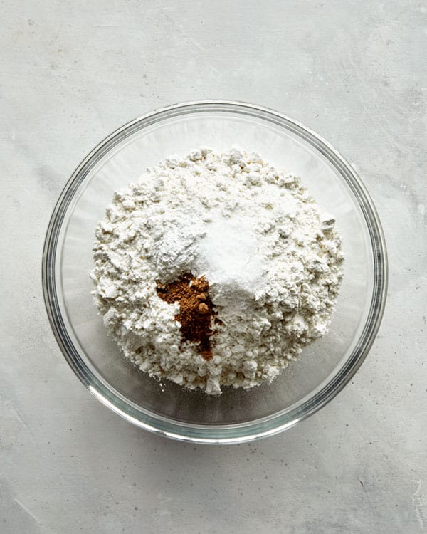 Adding dry ingredients to a bowl for old fashioned donuts. 