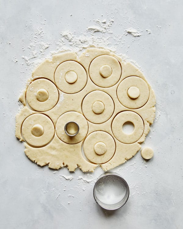 Donuts being cut out with a cutter.