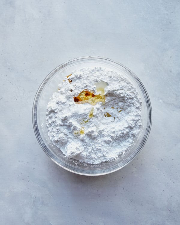 Ingredients for a vanilla glaze in a glass bowl. 