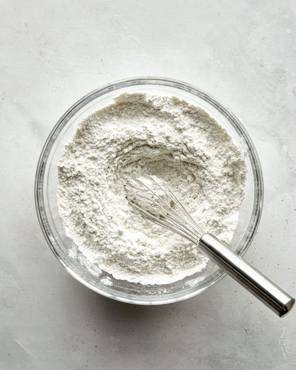 Dry ingredients whisked together in a glass bowl.