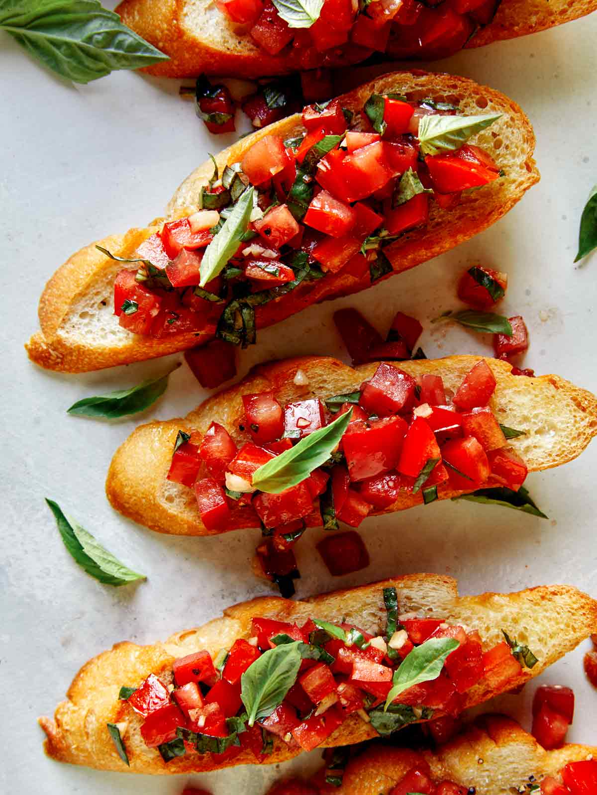 Bruschetta on toasted baguettes with basil.