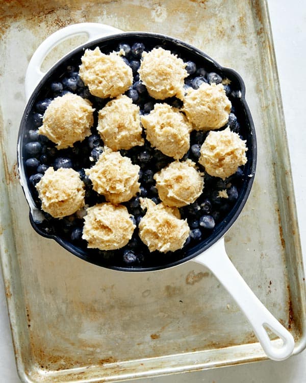 Blueberry cobbler in a skillet ready for the oven.