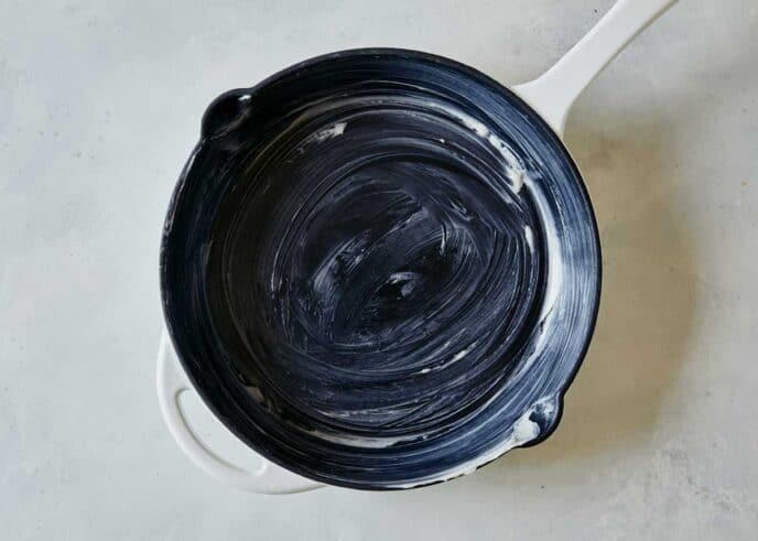 A buttered skillet to make blueberry cobbler.