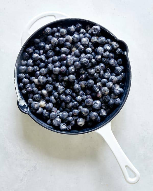 Blueberry cobbler filling in a skillet.