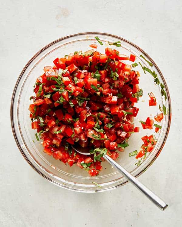 Bruschetta ingredients mixed together in a bowl. 