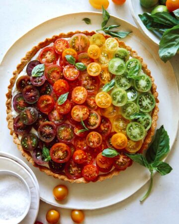 Heirloom tomato tart on a plate with fresh basil.