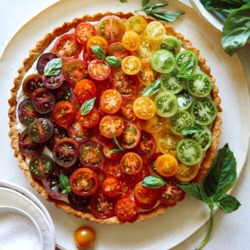 Heirloom tomato tart on a plate with fresh basil.