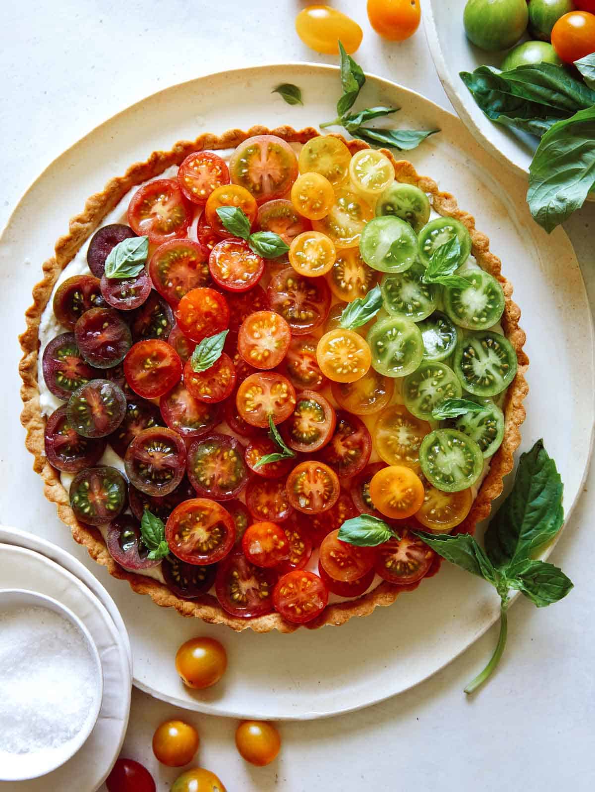 Heirloom tomato tart on a plate with fresh basil. 