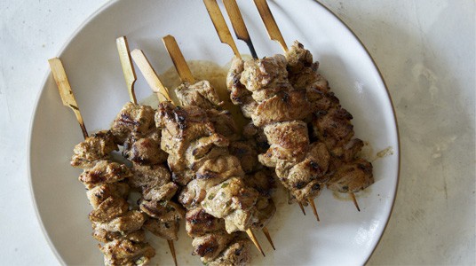 Grilled lamb kabobs on a plate resting.